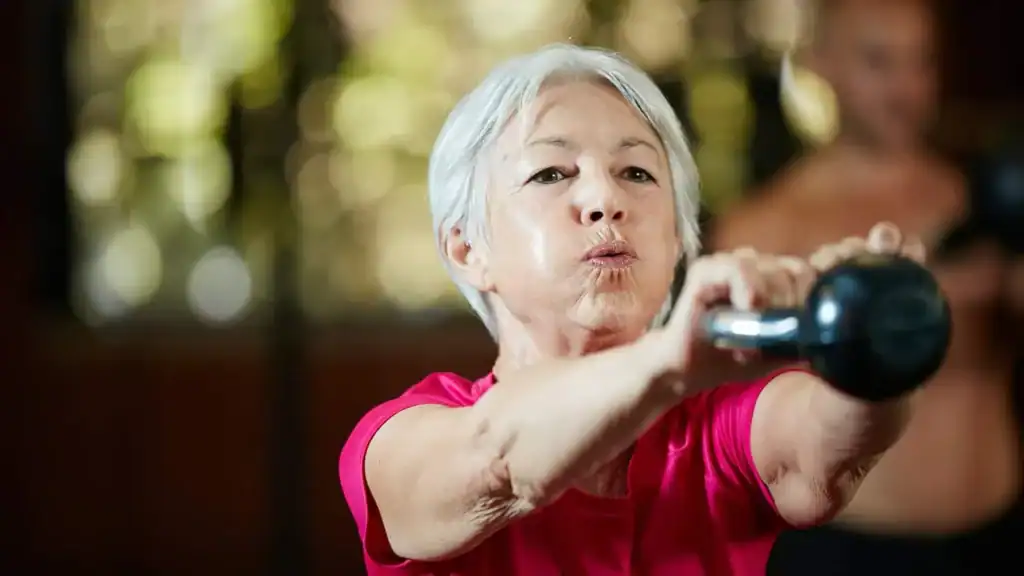 Older woman doing weight training Gravesend to help her strength and longevity 