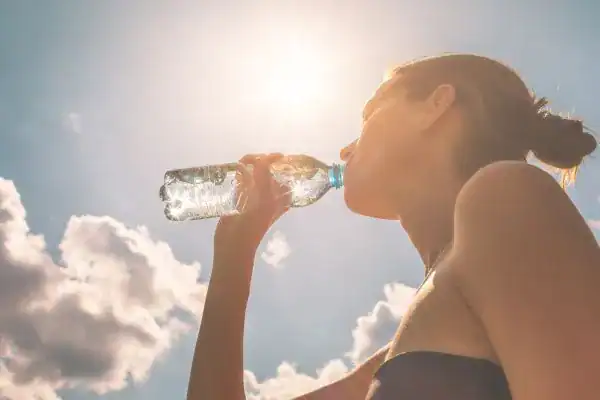 Hydration: The Secret Ingredient for a Toned Stomach and Enhanced Fitness 3 Image of woman drinking water to hydrate Gravesend after run.